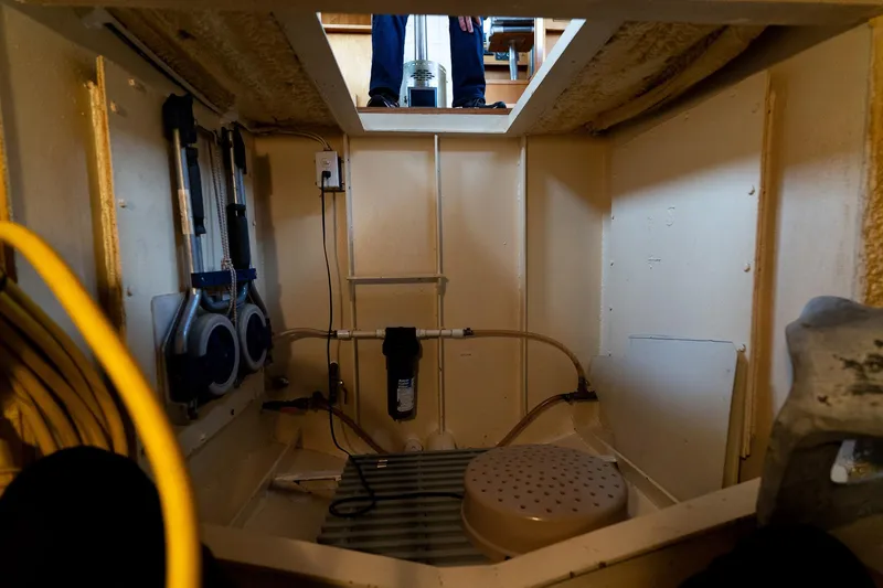 Slide: The Image of Interior view of a 1997 Custom Steel Trawler's engine room, showcasing equipment and wiring. - 43