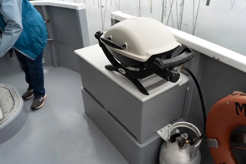 Slide: The Image of Outdoor grill on 1997 Custom Steel Trawler deck with propane tank and life preserver. - 6