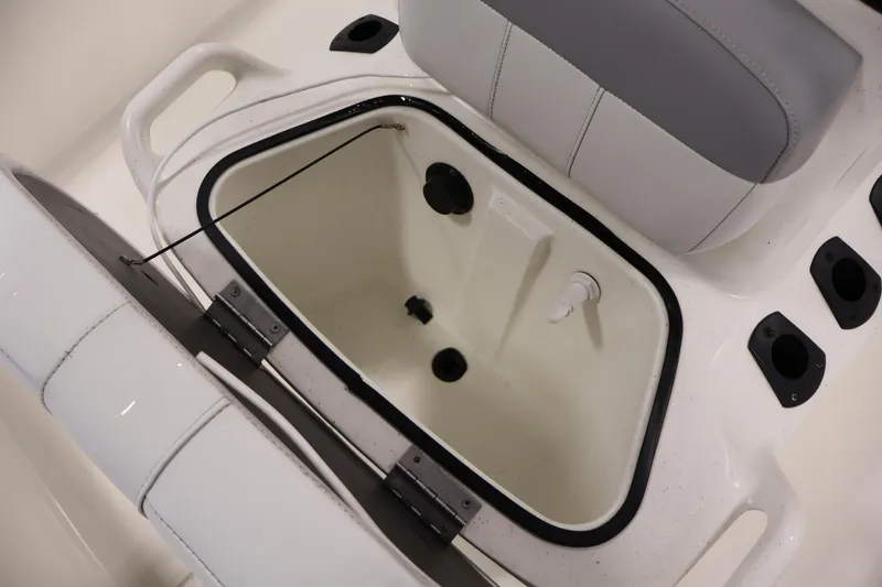 Slide: The Image of 2022 Mako Pro Skiff 17 CC boat storage compartment with seating and cup holders. - 14