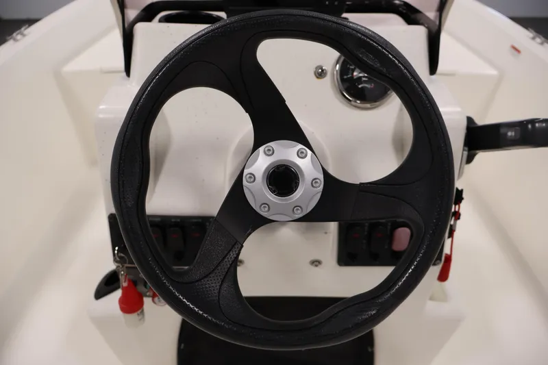 Slide: The Image of Steering wheel of a 2022 Mako Pro Skiff 17 CC boat. - 18