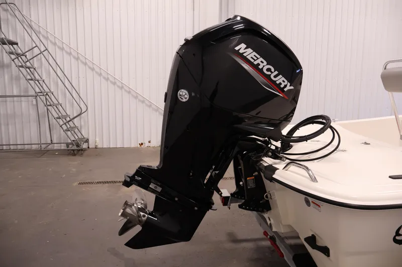 Slide: The Image of 2022 Mako Pro Skiff 17 CC with Mercury outboard motor in a garage setting. - 30
