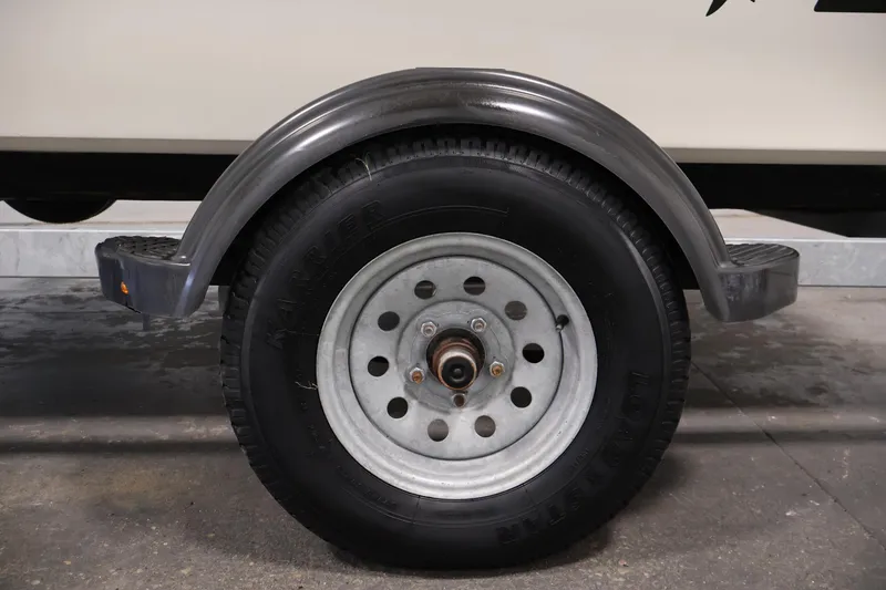 Slide: The Image of Trailer wheel of a 2022 Mako Pro Skiff 17 CC boat, close-up view. - 36