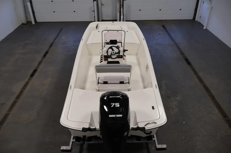 Slide: The Image of 2022 Mako Pro Skiff 17 CC boat with Mercury 75 engine in a garage. - 9
