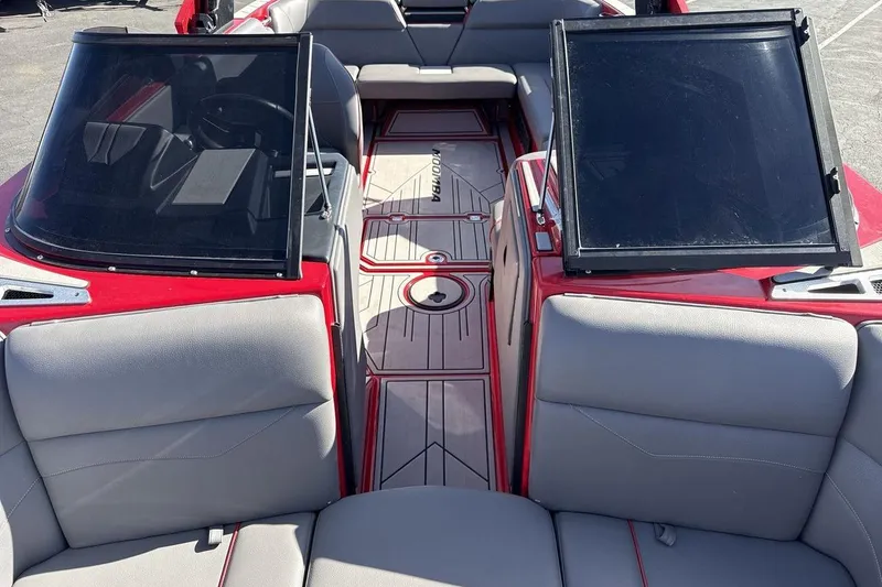 Slide: The Image of 2022 Moomba Mojo boat interior with red accents and gray seating. - 12