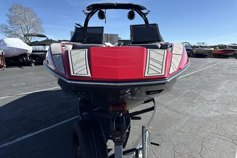 Slide: The Image of 2022 Moomba Mojo boat in vibrant red, parked on a trailer in a marina. - 8