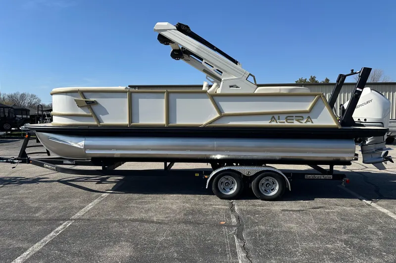 The Image of 2026 Alera M23Q pontoon boat on trailer, featuring sleek design and Mercury outboard motor. - 0