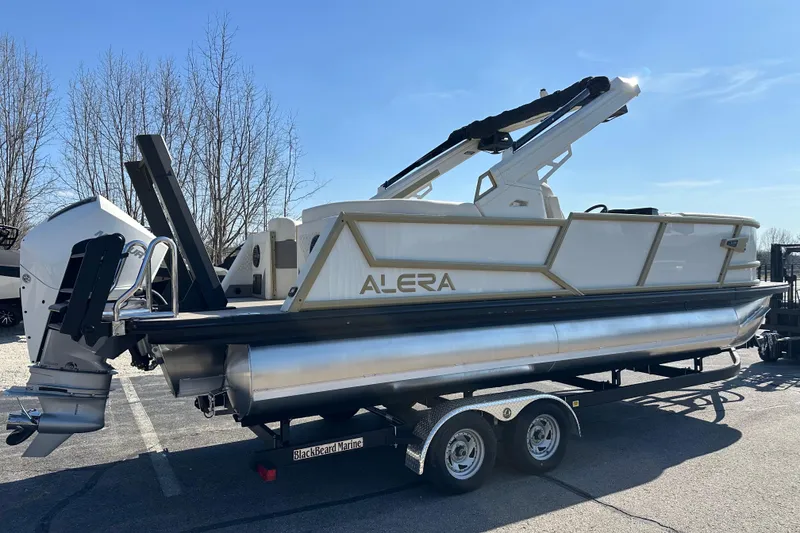Slide: The Image of Alera M23Q 2026 pontoon boat on trailer under clear blue sky. - 5