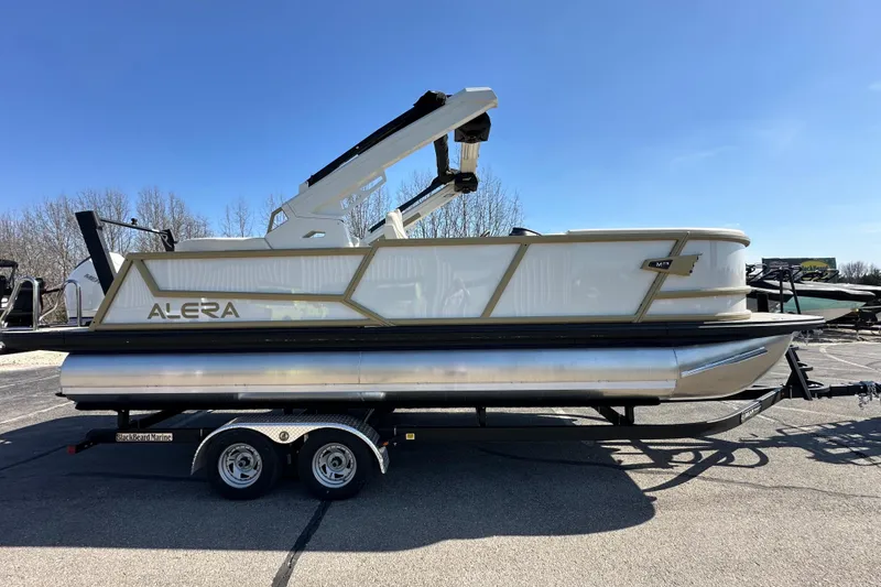 Slide: The Image of 2026 Alera M23Q pontoon boat on trailer under clear blue sky. - 8