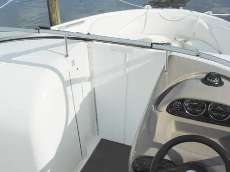 Slide: The Image of 2005 Regal 2400 Bowrider boat docked at marina with clear sky background. - 1