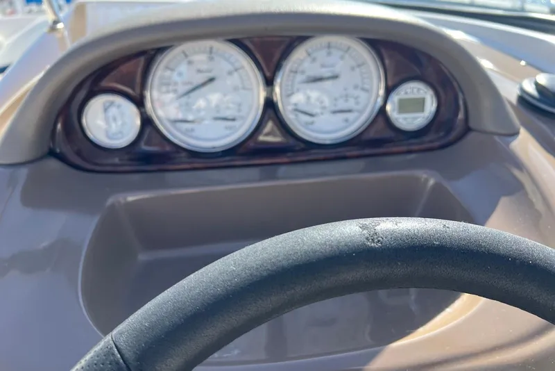 Slide: The Image of Dashboard of a 2005 Regal 2400 Bowrider boat with gauges and steering wheel. - 11