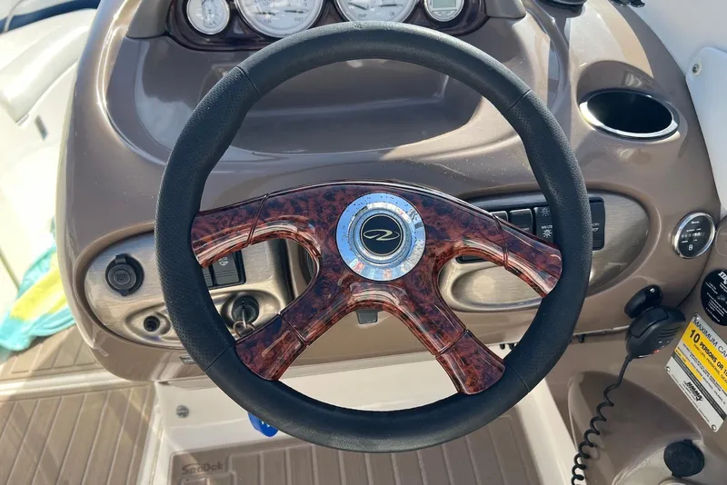 Slide: The Image of Steering wheel of a 2005 Regal 2400 Bowrider boat with dashboard controls. - 13