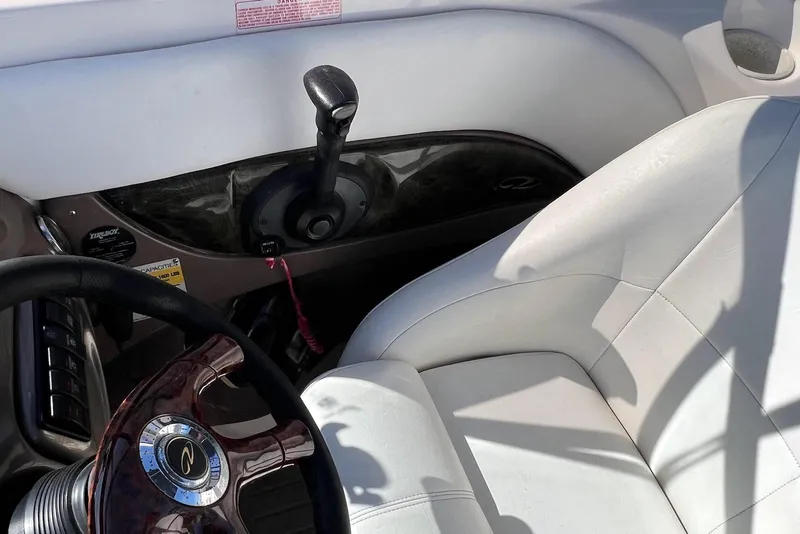 Slide: The Image of Interior of a 2005 Regal 2400 Bowrider boat, featuring steering wheel and controls. - 14