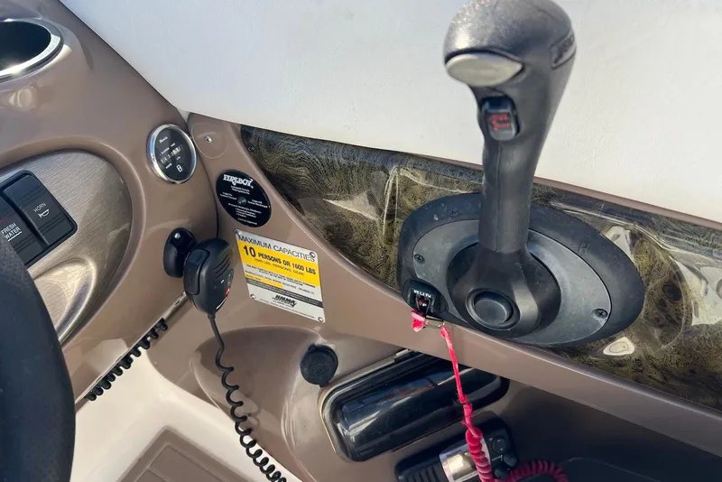 Slide: The Image of Control panel of a 2005 Regal 2400 Bowrider boat with throttle and capacity label. - 15