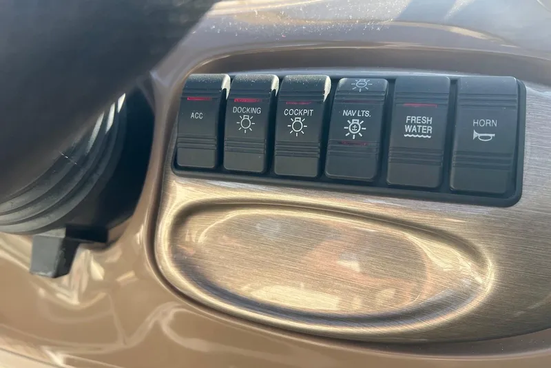 Slide: The Image of Dashboard controls of a 2005 Regal 2400 Bowrider boat, featuring various function switches. - 16