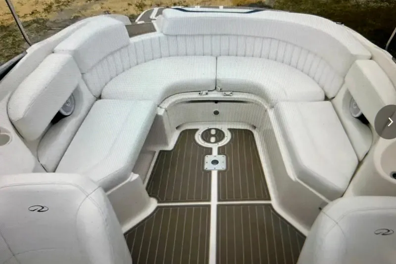 Slide: The Image of 2005 Regal 2400 Bowrider interior with white seating and wood-style flooring. - 20
