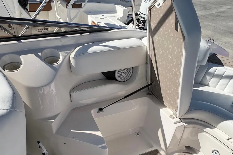 Slide: The Image of Interior of a 2005 Regal 2400 Bowrider boat, featuring white seating and cup holders. - 21
