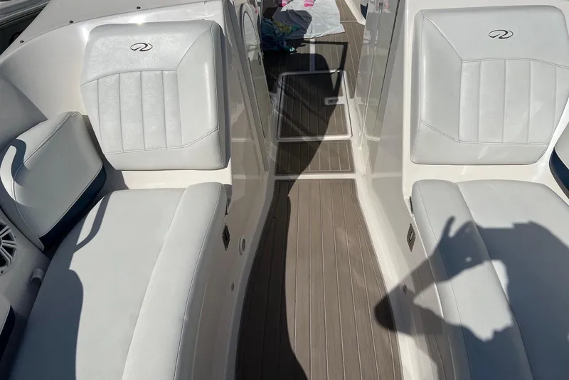 Slide: The Image of Interior of a 2005 Regal 2400 Bowrider boat with white seating and wood flooring. - 25