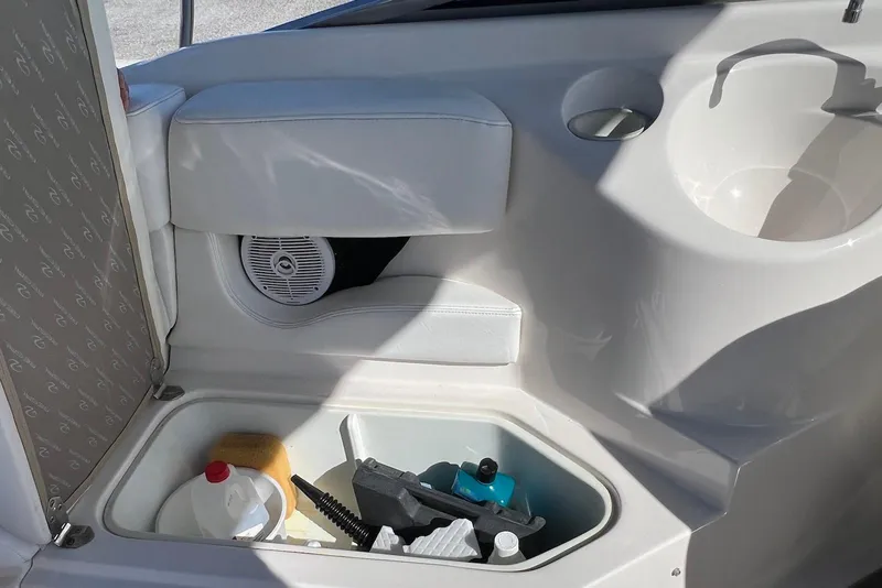 Slide: The Image of Storage compartment in a 2005 Regal 2400 Bowrider boat with cleaning supplies. - 31