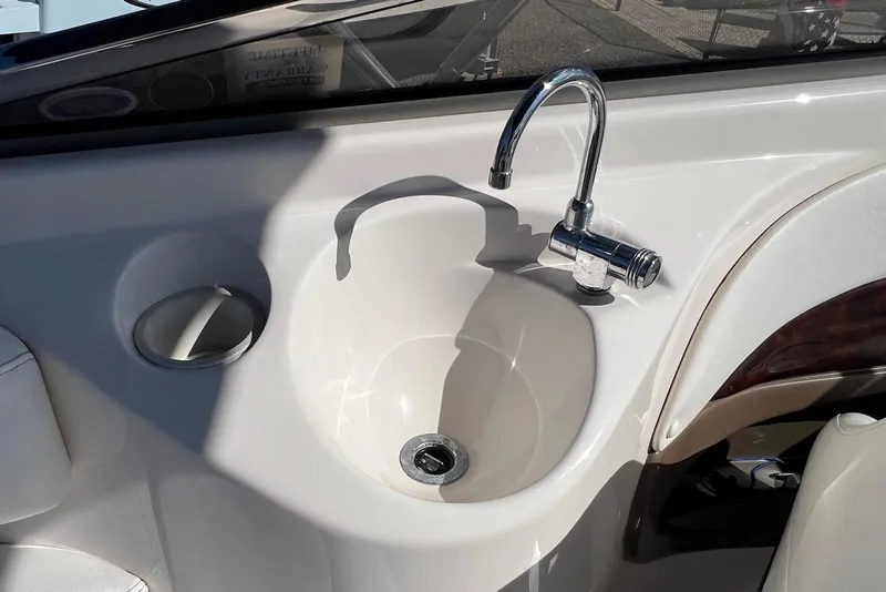 Slide: The Image of 2005 Regal 2400 Bowrider boat sink with chrome faucet and cup holder. - 32