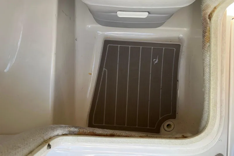Slide: The Image of Storage compartment in a 2005 Regal 2400 Bowrider boat, featuring a drain plug. - 35