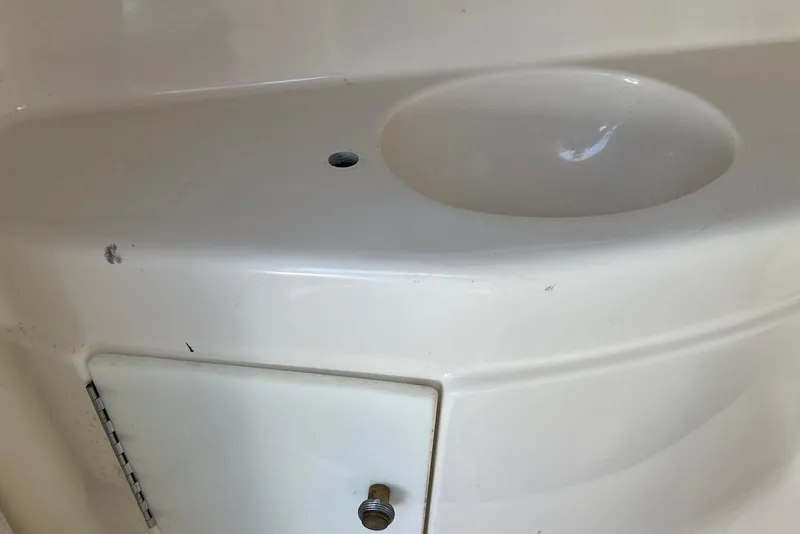 Slide: The Image of 2005 Regal 2400 Bowrider boat sink area with storage compartment. - 36