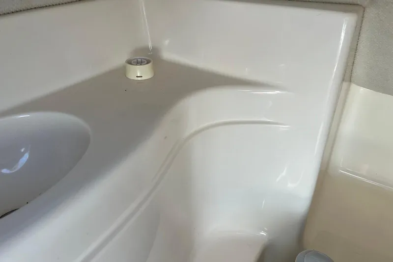 Slide: The Image of Interior detail of a 2005 Regal 2400 Bowrider boat, featuring white fiberglass surfaces. - 37