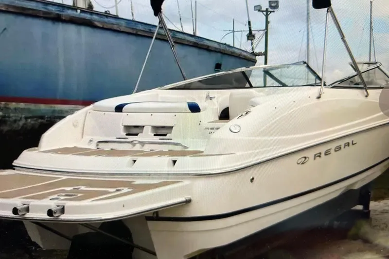 Slide: The Image of 2005 Regal 2400 Bowrider boat docked, showcasing sleek design and spacious deck. - 40