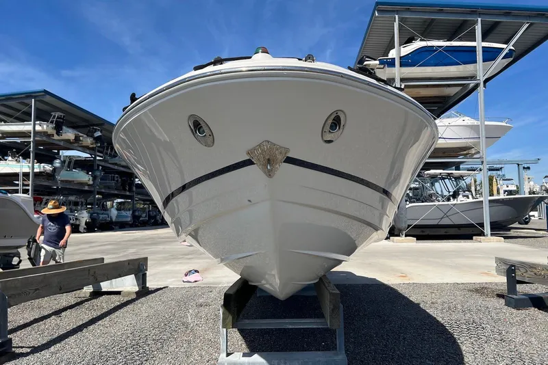 Slide: The Image of 2005 Regal 2400 Bowrider boat on display at a marina with storage racks. - 6