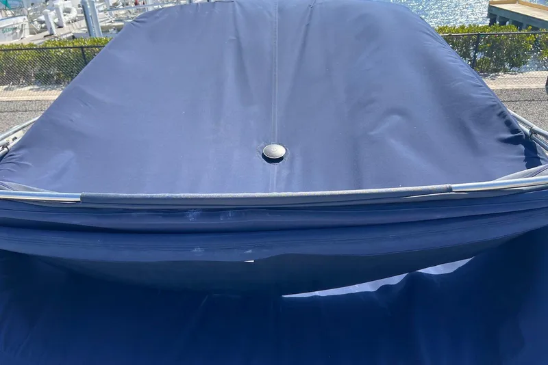 Slide: The Image of 2005 Regal 2400 Bowrider with blue cover at marina. - 9