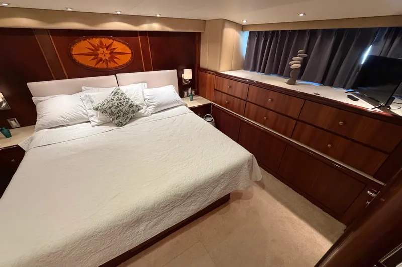 Slide: The Image of Luxurious bedroom in a 1991 Hatteras 70 Motor Yacht with elegant wood cabinetry. - 101