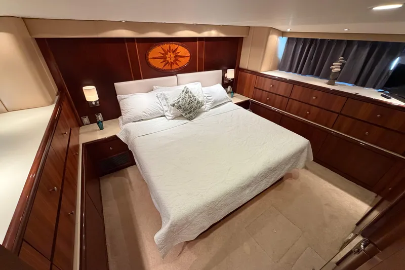 Slide: The Image of Luxurious bedroom interior of 1991 Hatteras 70 Motor Yacht with elegant wood paneling. - 103