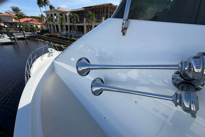 Slide: The Image of 1991 Hatteras 70 Motor Yacht docked in a scenic marina with clear skies. - 11