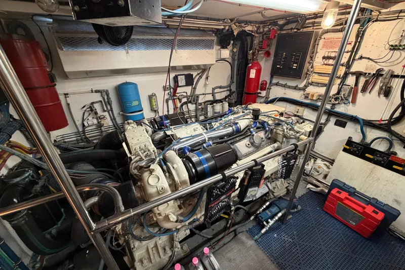Slide: The Image of Engine room of a 1991 Hatteras 70 Motor Yacht, showcasing detailed machinery and wiring. - 113