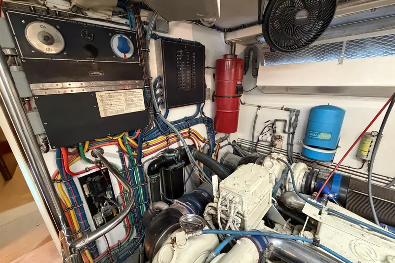 Slide: The Image of Engine room of a 1991 Hatteras 70 Motor Yacht, featuring complex machinery and tools. - 114