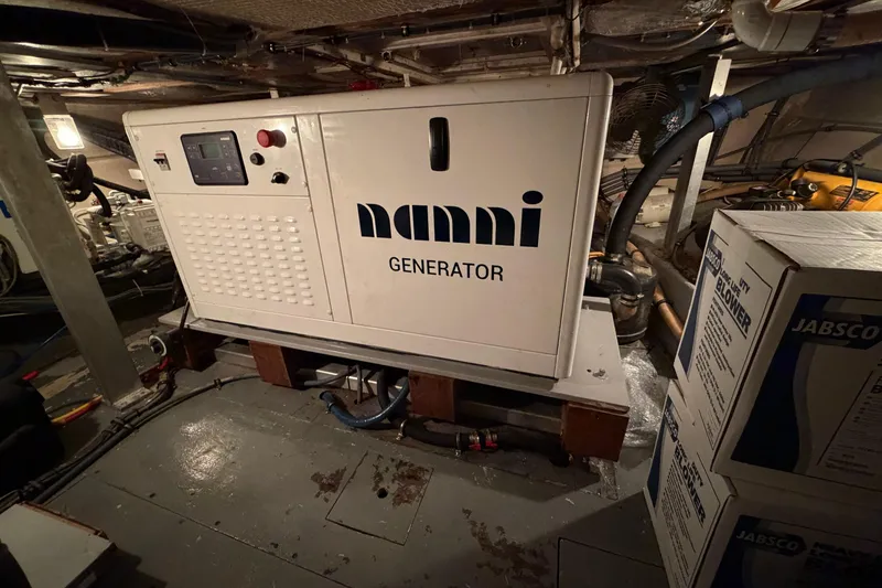 Slide: The Image of Engine room of a 1991 Hatteras 70 Motor Yacht, showcasing complex machinery and wiring. - 116