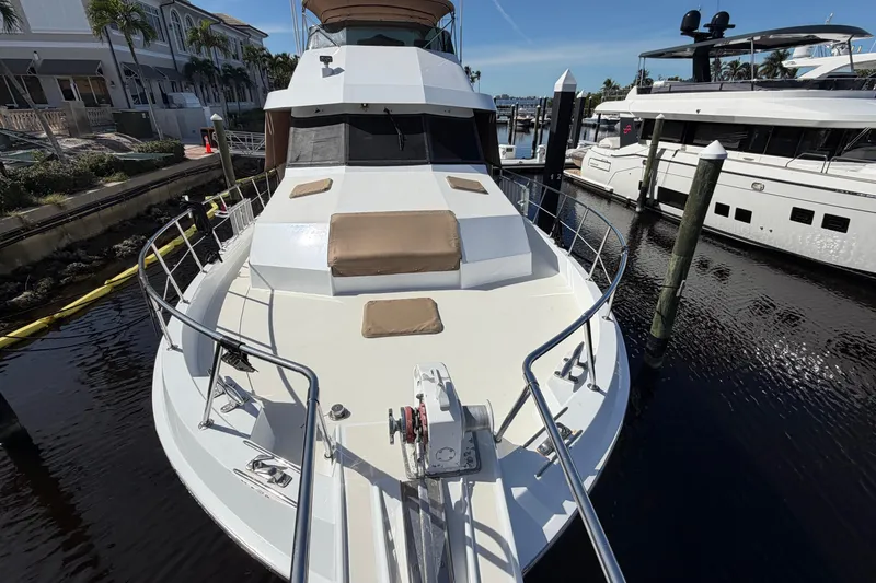 Slide: The Image of 1991 Hatteras 70 Motor Yacht docked in a sunny marina with waterfront homes. - 14