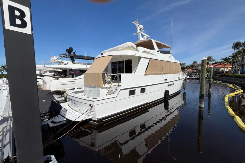 Slide: The Image of 1991 Hatteras 70 Motor Yacht docked, featuring spacious deck and sleek design. - 15
