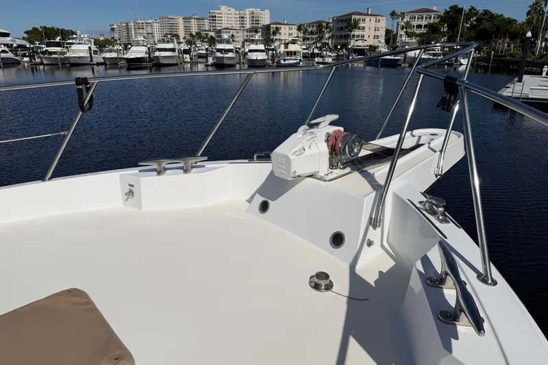 Slide: The Image of 1991 Hatteras 70 Motor Yacht docked at marina under clear blue sky. - 16