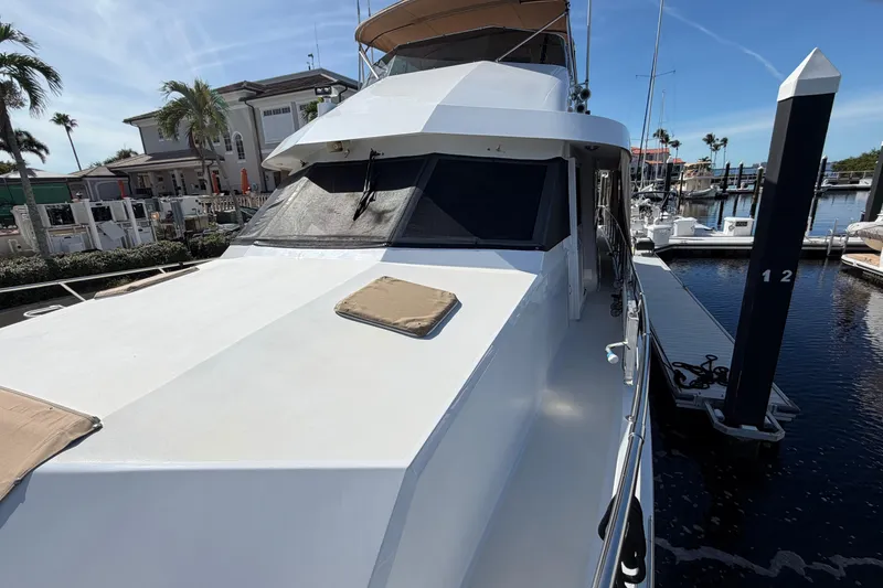 Slide: The Image of 1991 Hatteras 70 Motor Yacht docked, showcasing sleek design and spacious deck. - 20