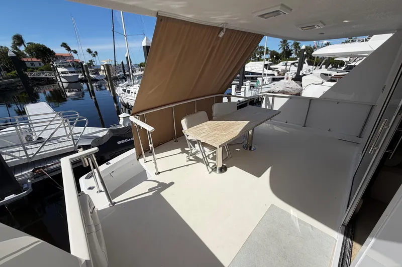 Slide: The Image of 1991 Hatteras 70 Motor Yacht aft deck with table, chairs, and marina view. - 33