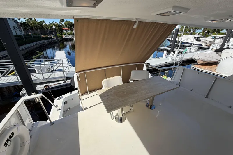 Slide: The Image of 1991 Hatteras 70 Motor Yacht aft deck with table, chairs, and marina view. - 34