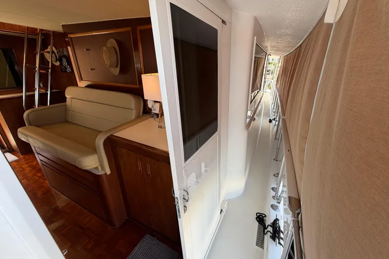 Slide: The Image of 1991 Hatteras 70 Motor Yacht aft deck with seating, table, and marina view. - 36