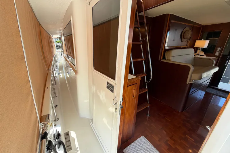 Slide: The Image of Interior view of 1991 Hatteras 70 Motor Yacht, featuring elegant seating and wood finishes. - 37