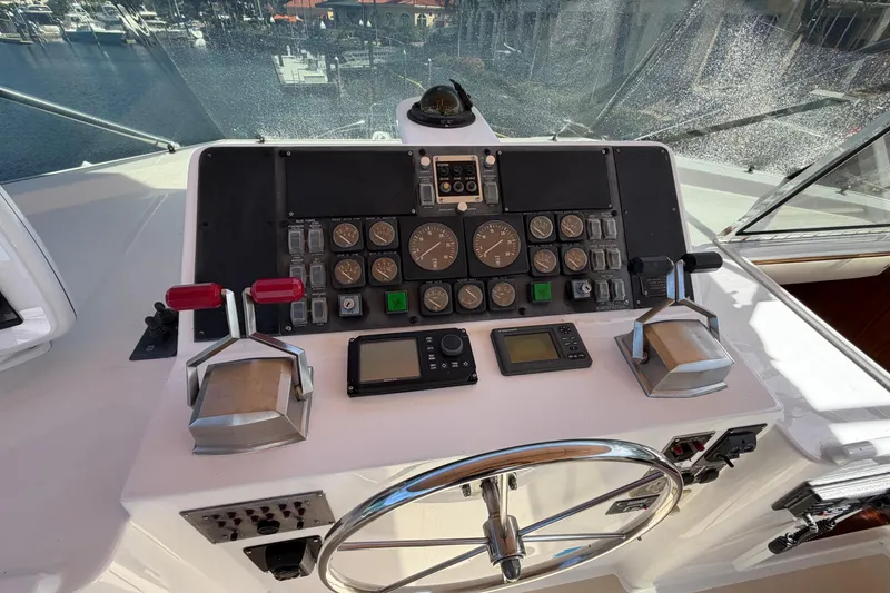 Slide: The Image of 1991 Hatteras 70 Motor Yacht deck with seating, docked in marina under clear blue sky. - 43