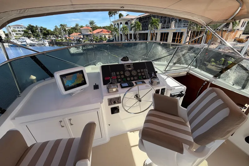 Slide: The Image of 1991 Hatteras 70 Motor Yacht helm with navigation equipment and striped seating. - 45