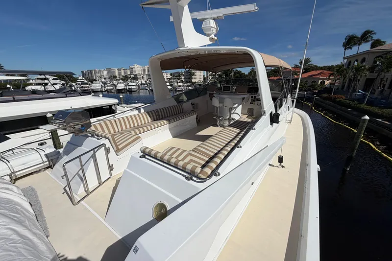 Slide: The Image of 1991 Hatteras 70 Motor Yacht with spacious deck, seating, and grill in marina setting. - 50