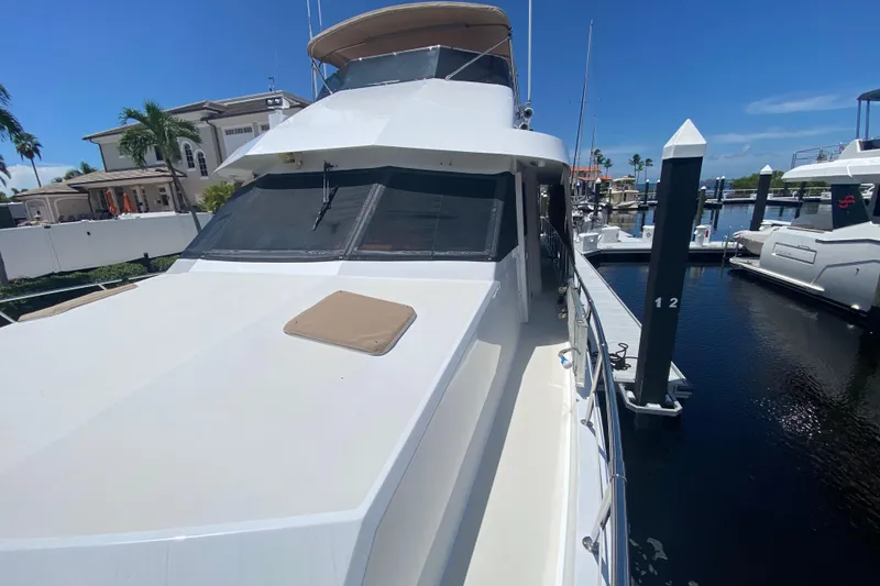 Slide: The Image of 1991 Hatteras 70 Motor Yacht docked at marina under clear blue sky. - 6