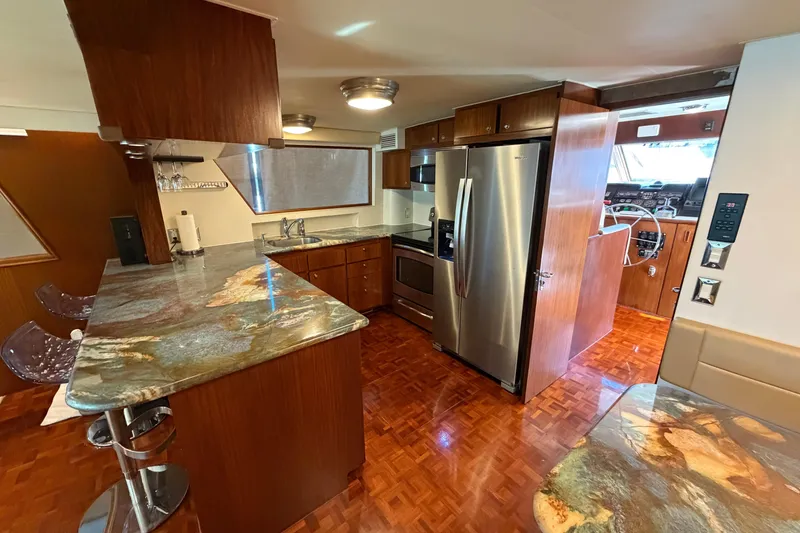 Slide: The Image of Luxurious interior of a 1991 Hatteras 70 Motor Yacht with modern kitchen and seating area. - 65
