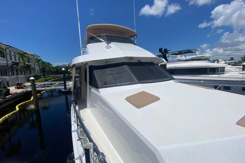 Slide: The Image of 1991 Hatteras 70 Motor Yacht docked at marina under clear blue sky. - 7