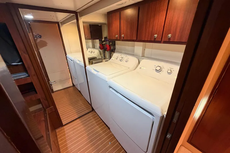 Slide: The Image of Laundry area in 1991 Hatteras 70 Motor Yacht with washer, dryer, and wooden cabinetry. - 99